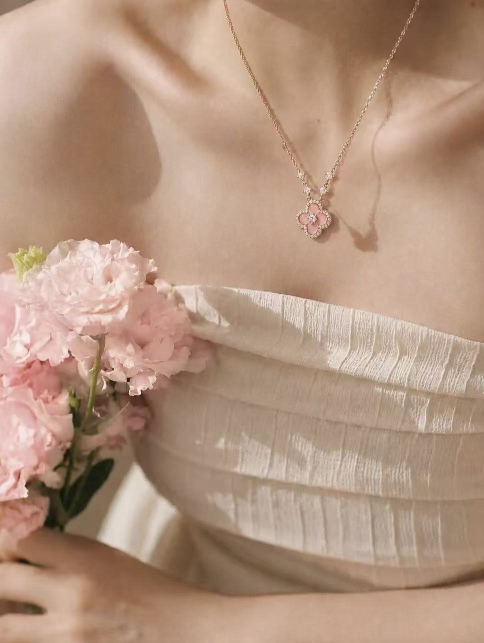 A pink floral pendant and fresh pink flowers